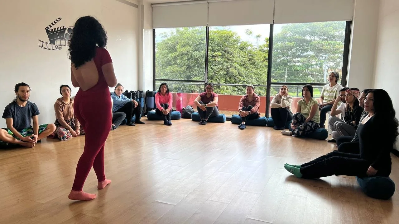 Gabriela facilita un encuentro ante un grupo sentado en círculo en la sala