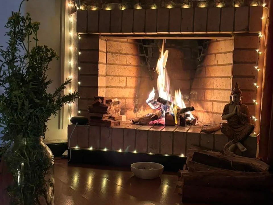 La chimenea encendida y las luces cálidas del espacio de encuentro